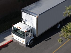 a medium rigid white truck ,moving forward indicating a mr licence requirements