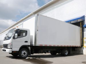 a white medium rigid vehicle parked in a warehouse