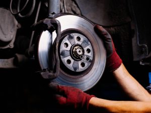 Mechanic performing a maintenance check on a truck’s brake system to ensure safety and roadworthiness.