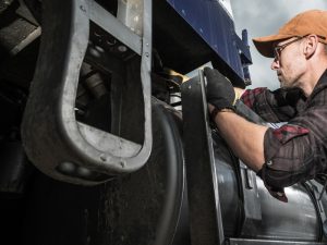 Driver examining truck tyres and components to identify reasons for the truck losing power unexpectedly.