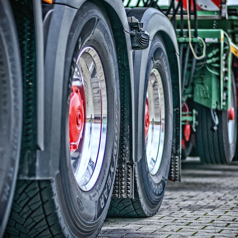Truck driving school training vehicle showing close-up of heavy truck wheels and tyres parked on paved ground